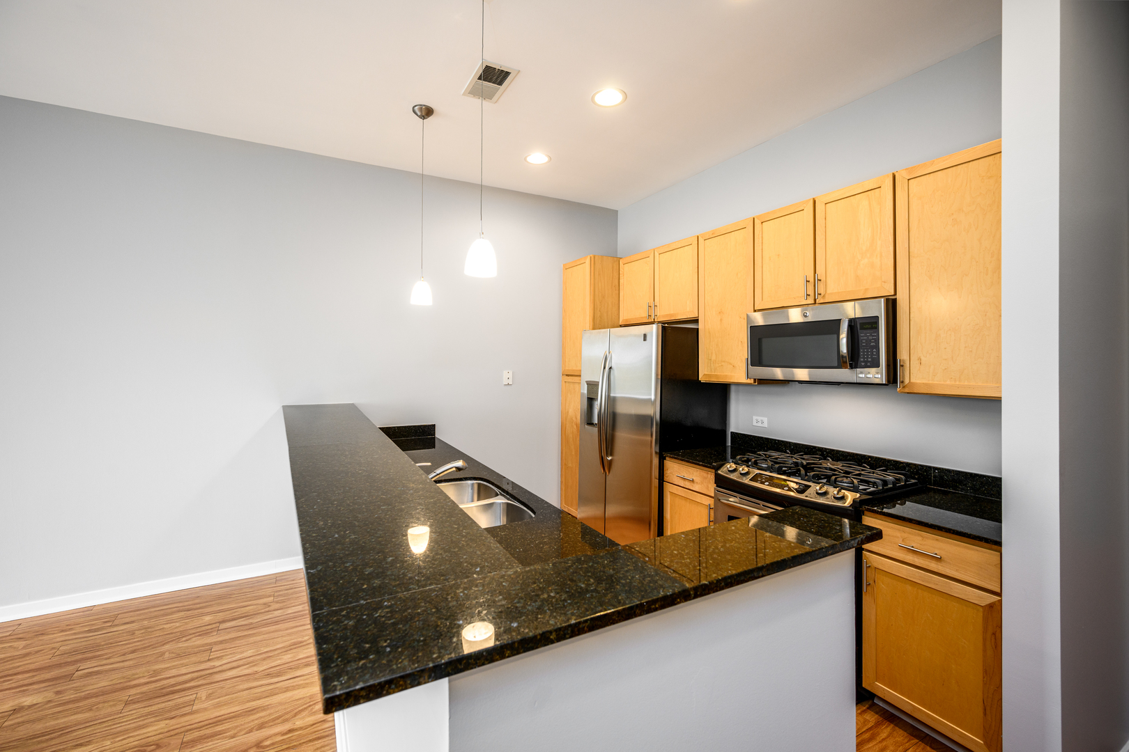 3920 North Sheridan Road, Unit 406 Chicago, IL 60613 - Photo 5 of 12 a kitchen with stainless steel appliances granite countertop a sink refrigerator and stove