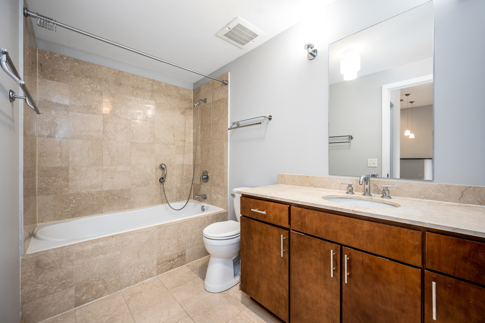 3920 North Sheridan Road, Unit 406 Chicago, IL 60613 - Photo 8 of 12 a bathroom with a bathtub shower sink mirror and toilet