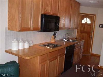 3215 Stringfellow Road, Unit 204 St. James City, FL 33956 - Photo 2 of 6 a kitchen with a sink a stove and cabinets