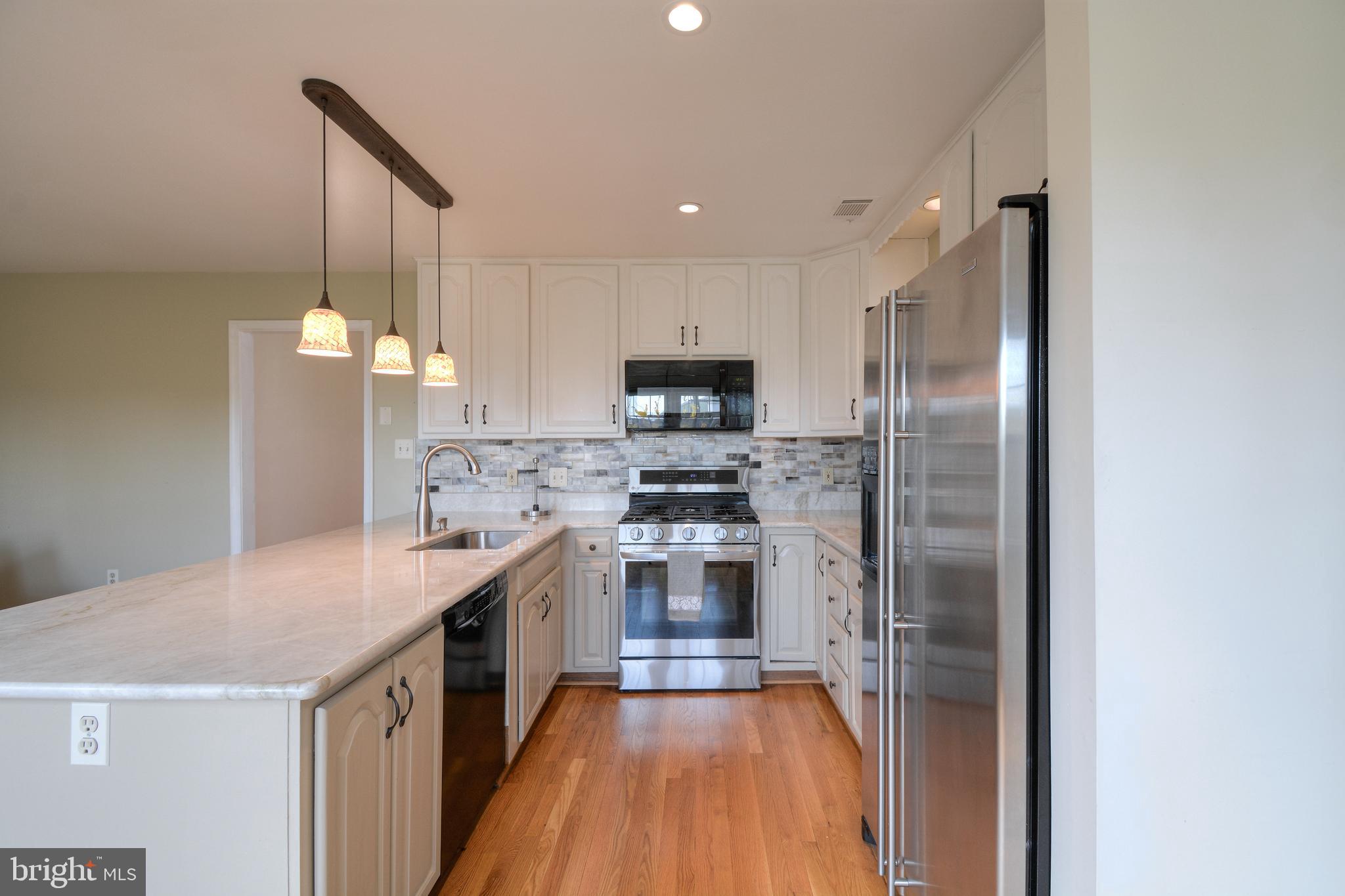 2457 Bear Den Road Frederick, MD 21701 - Photo 10 of 36 a kitchen with kitchen island a counter top space a sink and stainless steel appliances