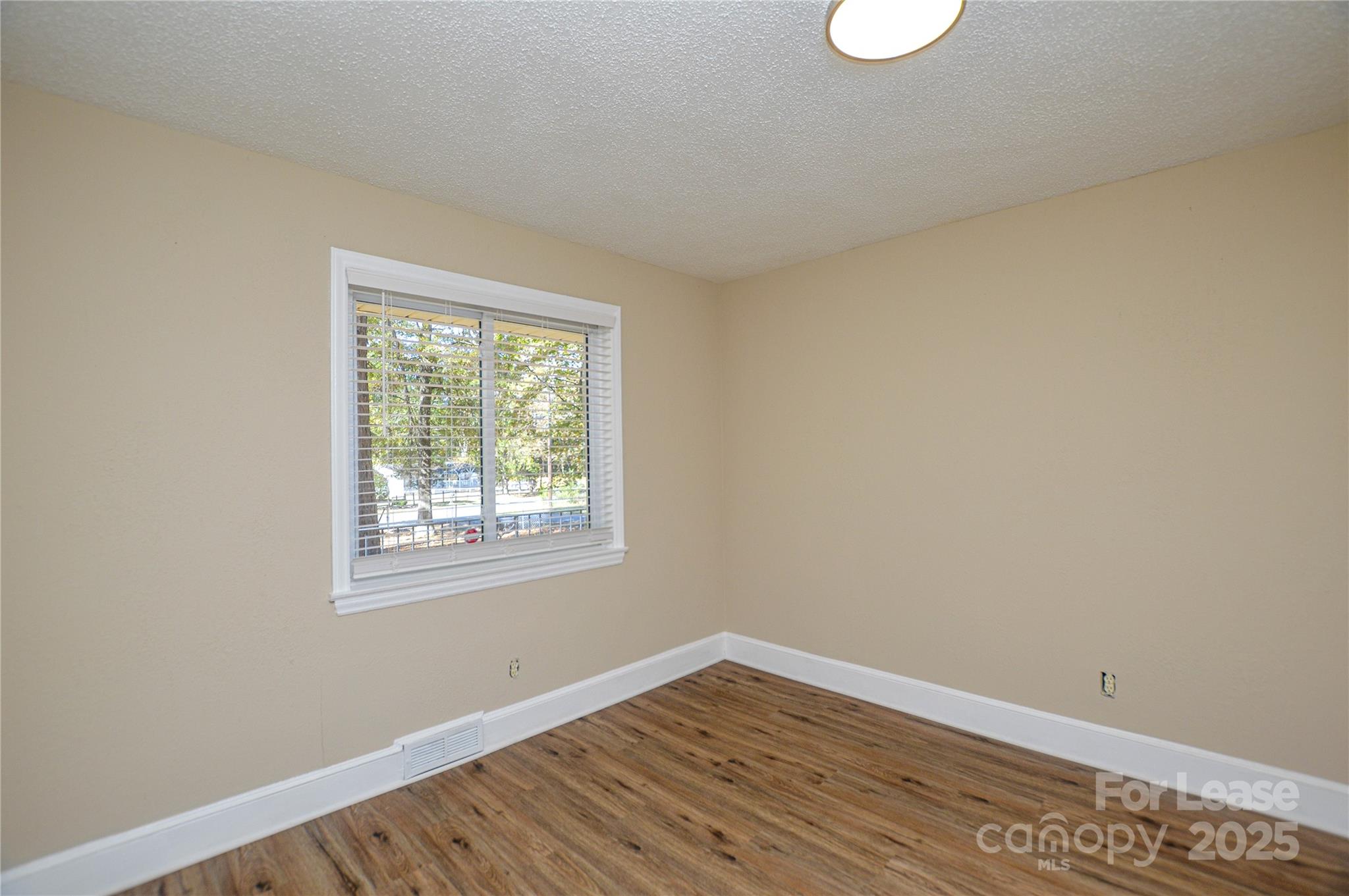 2511 Woodstar Road Matthews, NC 28105 - Photo 11 of 21 a view of an empty room with wooden floor and a window