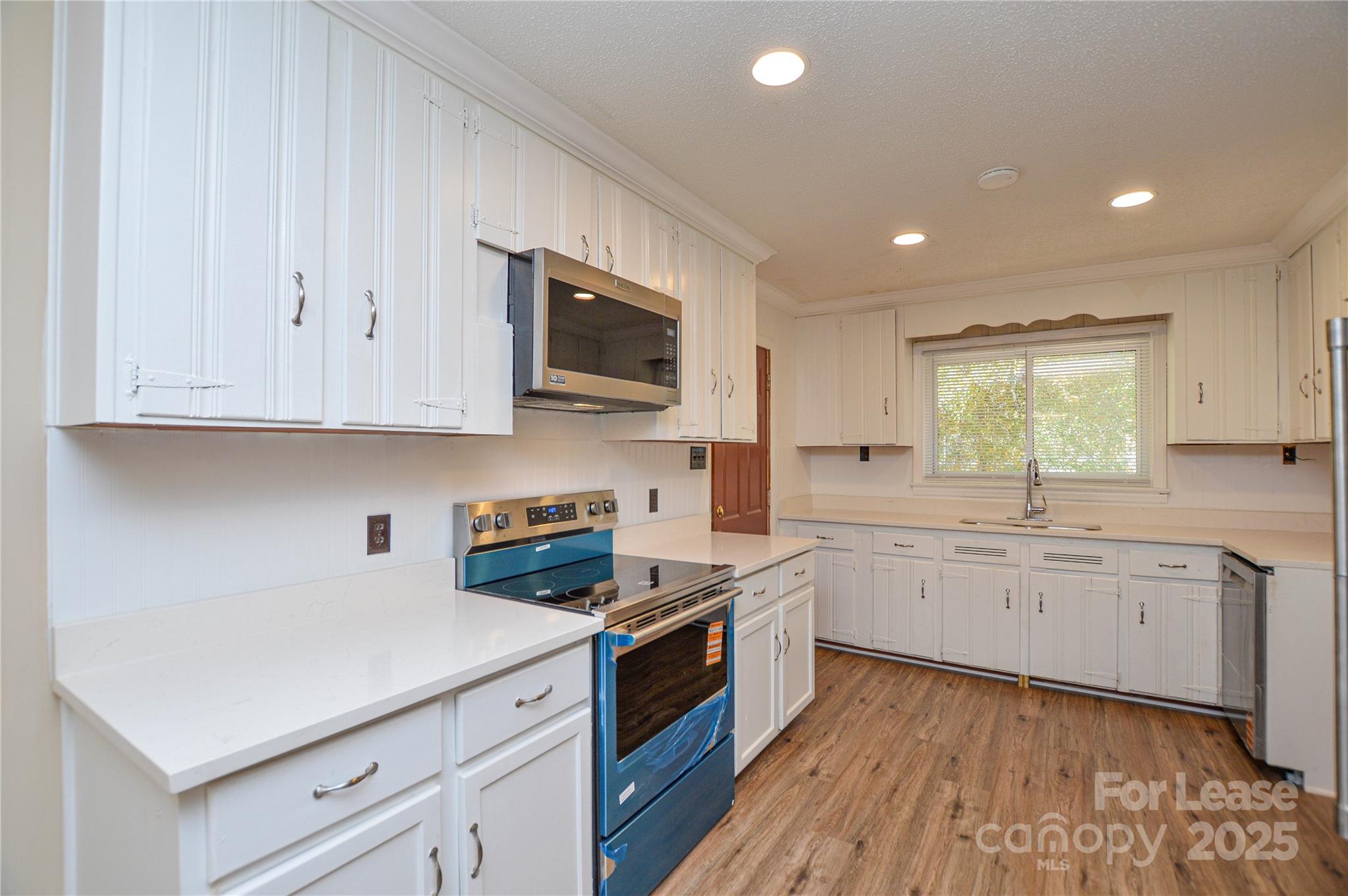 2511 Woodstar Road Matthews, NC 28105 - Photo 17 of 21 a kitchen with granite countertop cabinets stainless steel appliances a sink and a window