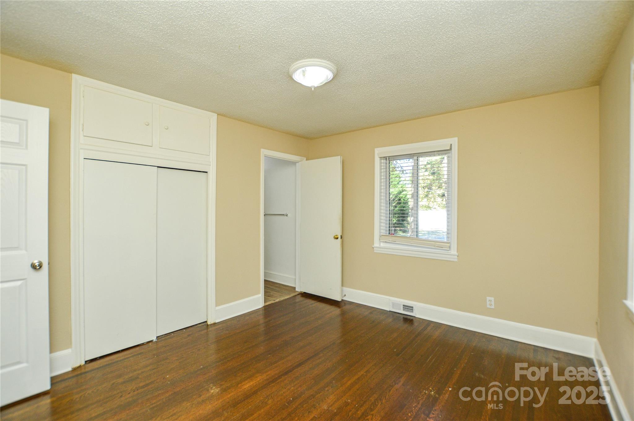 2511 Woodstar Road Matthews, NC 28105 - Photo 5 of 21 an empty room with wooden floor and windows