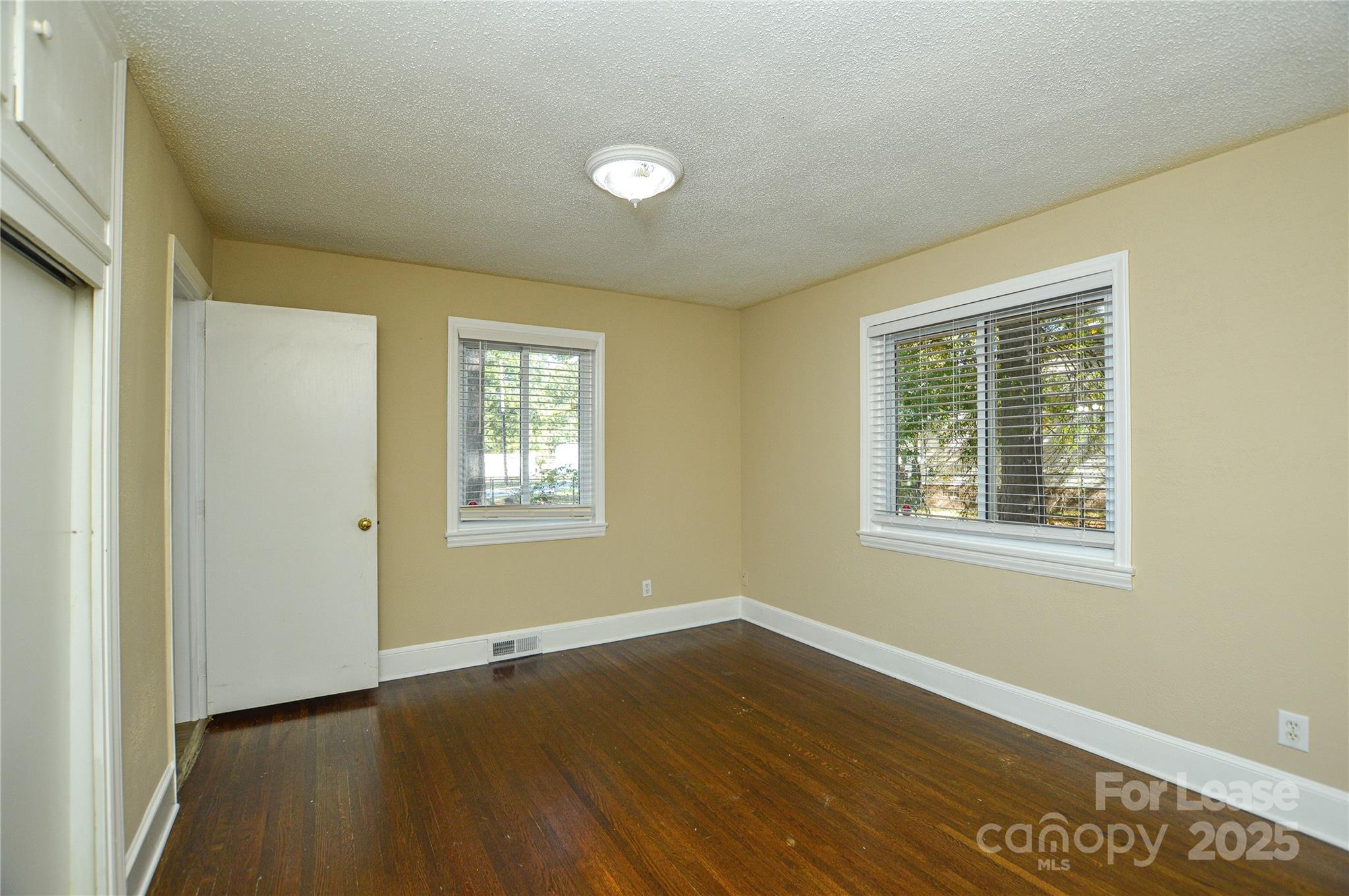 2511 Woodstar Road Matthews, NC 28105 - Photo 6 of 21 a view of an empty room with wooden floor and a window