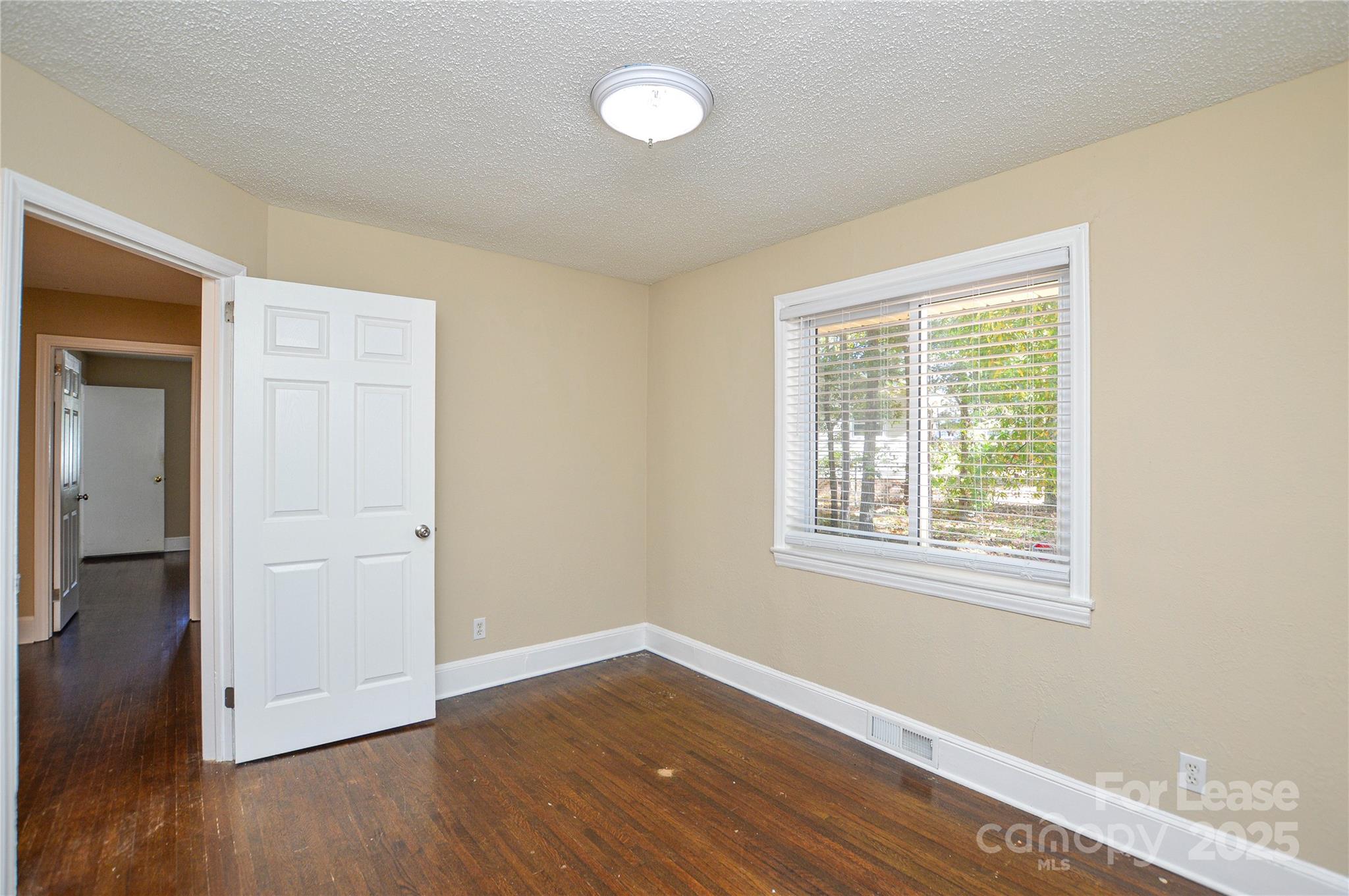 2511 Woodstar Road Matthews, NC 28105 - Photo 8 of 21 a view of an empty room with wooden floor and a window