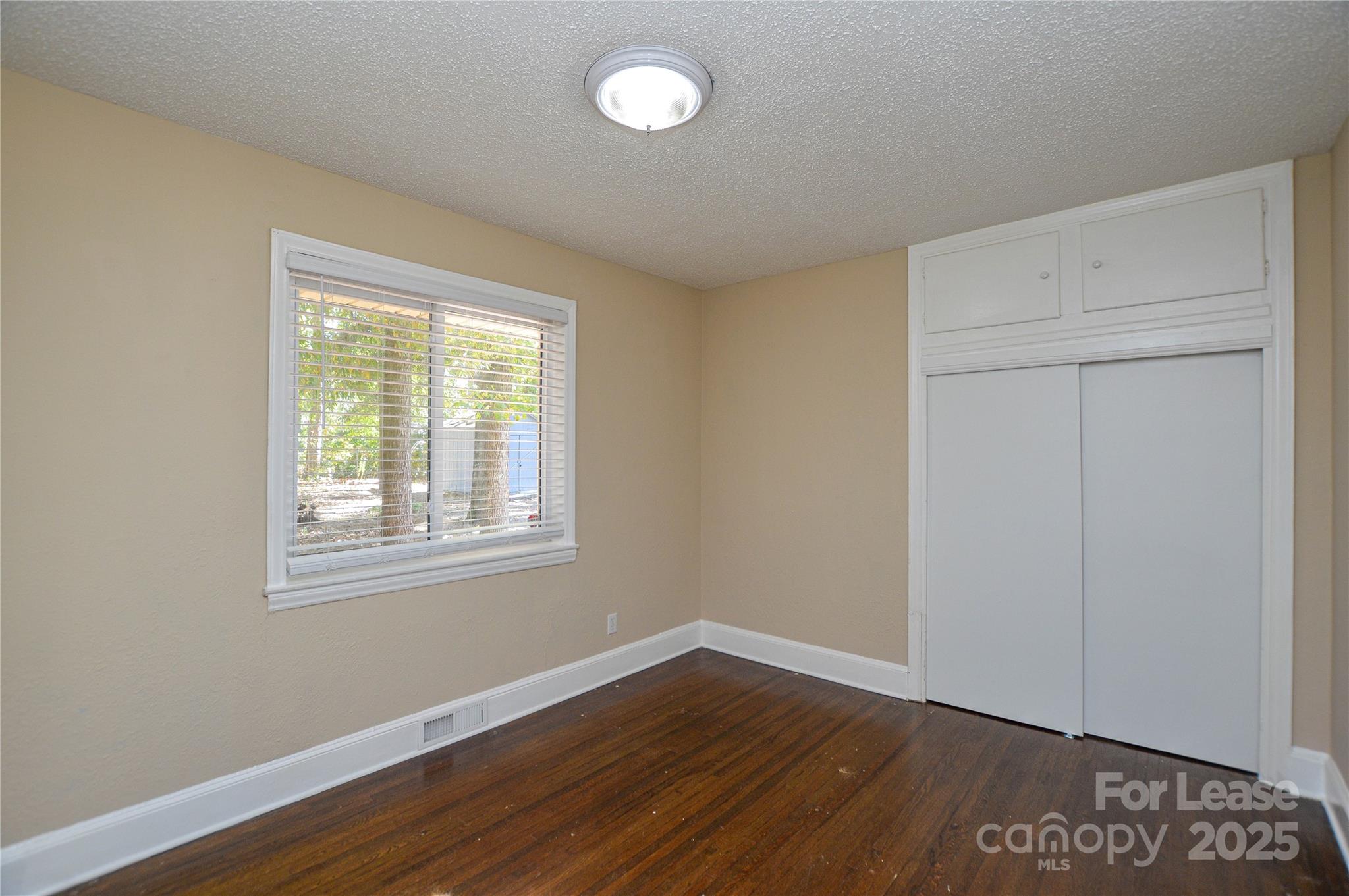 2511 Woodstar Road Matthews, NC 28105 - Photo 9 of 21 an empty room with wooden floor and windows