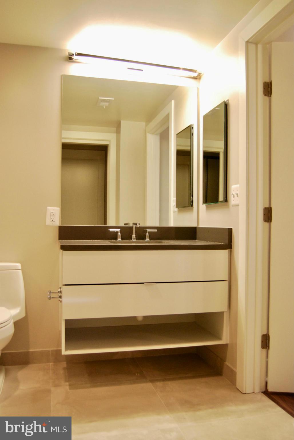 1311 13th Street Northwest, Unit 502 Washington, DC 20005 - Photo 18 of 21 a bathroom with a mirror and a toilet