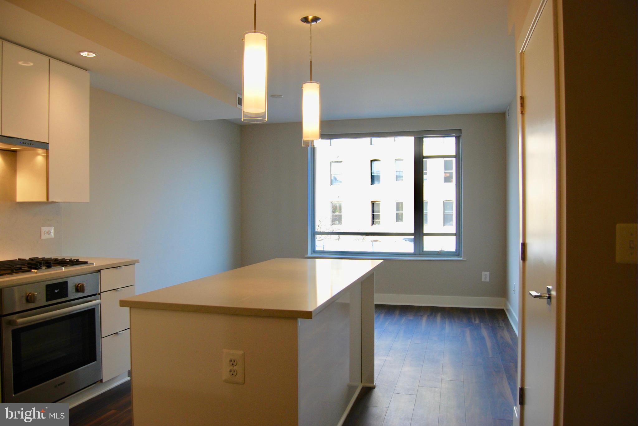 1311 13th Street Northwest, Unit 502 Washington, DC 20005 - Photo 8 of 21 a kitchen with a wooden floor and a window