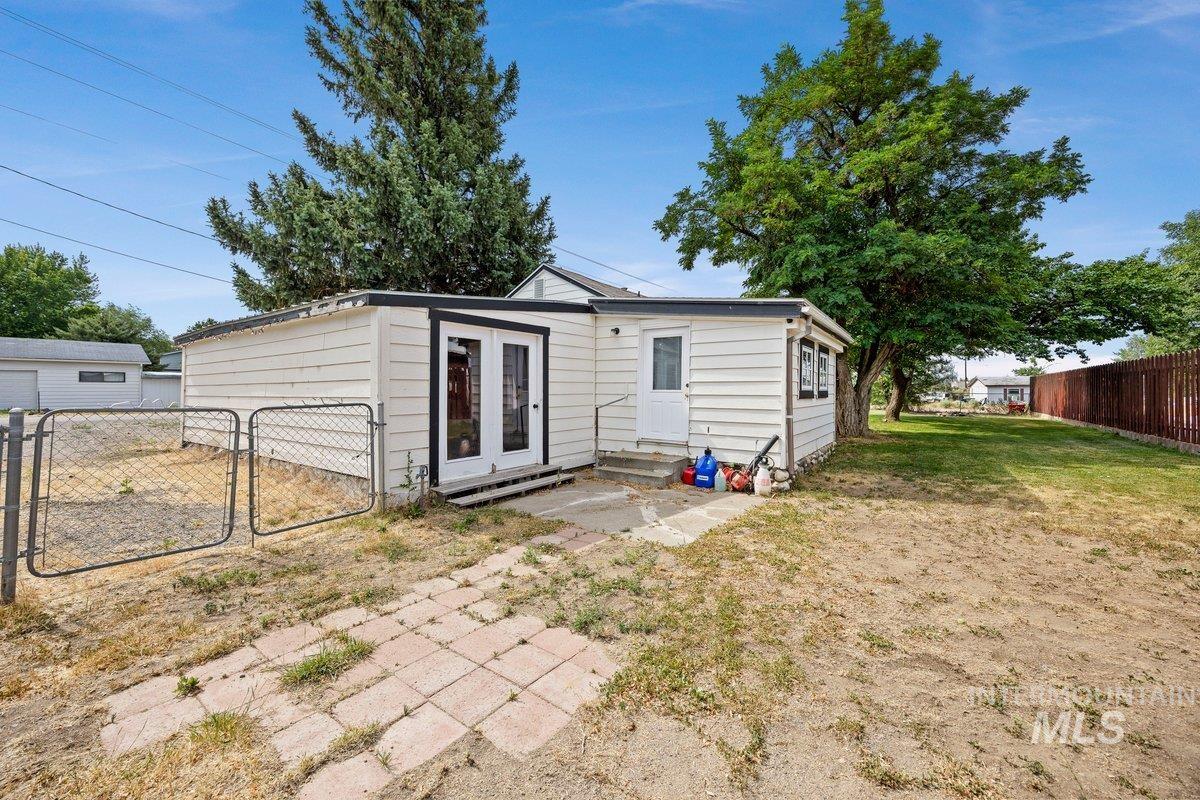 418 South Date Street Shoshone, ID 83352 - Photo 26 of 36 Rear exterior with white horizontal siding and black trim around windows and double glass doors