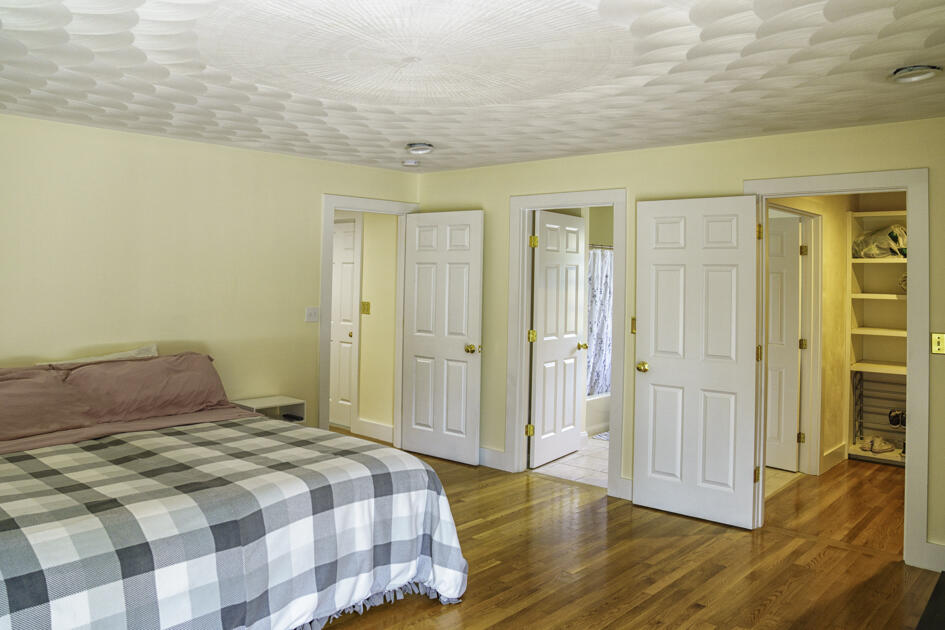 488 Upper County Road Dennis Port, MA 02639 - Photo 18 of 35 a bedroom with a bed and wooden floor