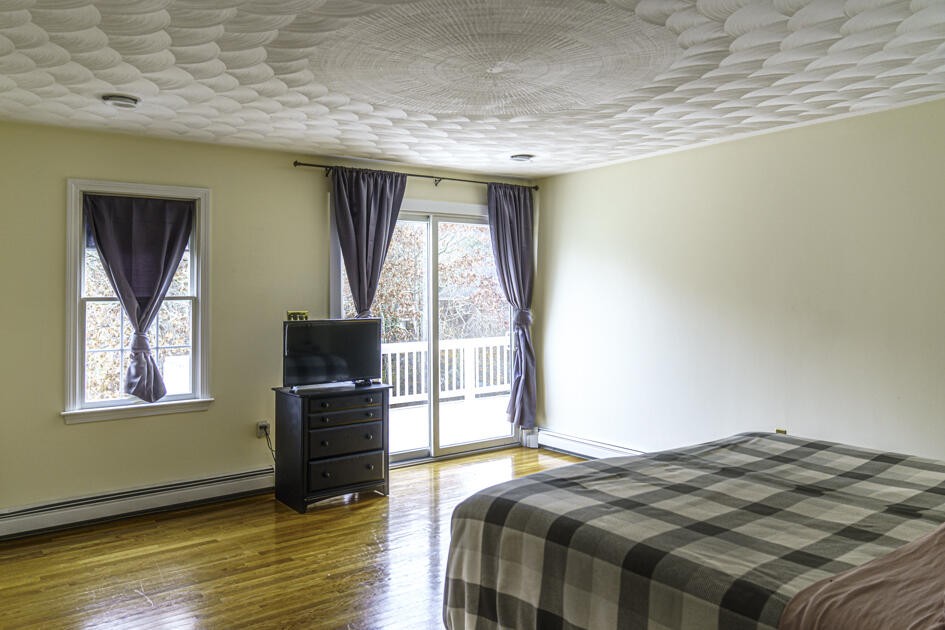 488 Upper County Road Dennis Port, MA 02639 - Photo 19 of 35 a bedroom with a bed and wooden floor