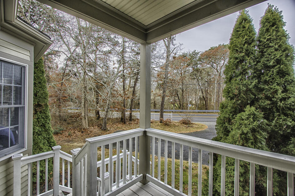 488 Upper County Road Dennis Port, MA 02639 - Photo 3 of 35 a view of a porch with a floor to ceiling window and wooden fence