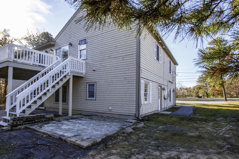 488 Upper County Road Dennis Port, MA 02639 - Photo 9 of 35 a view of a house with a yard and palm trees