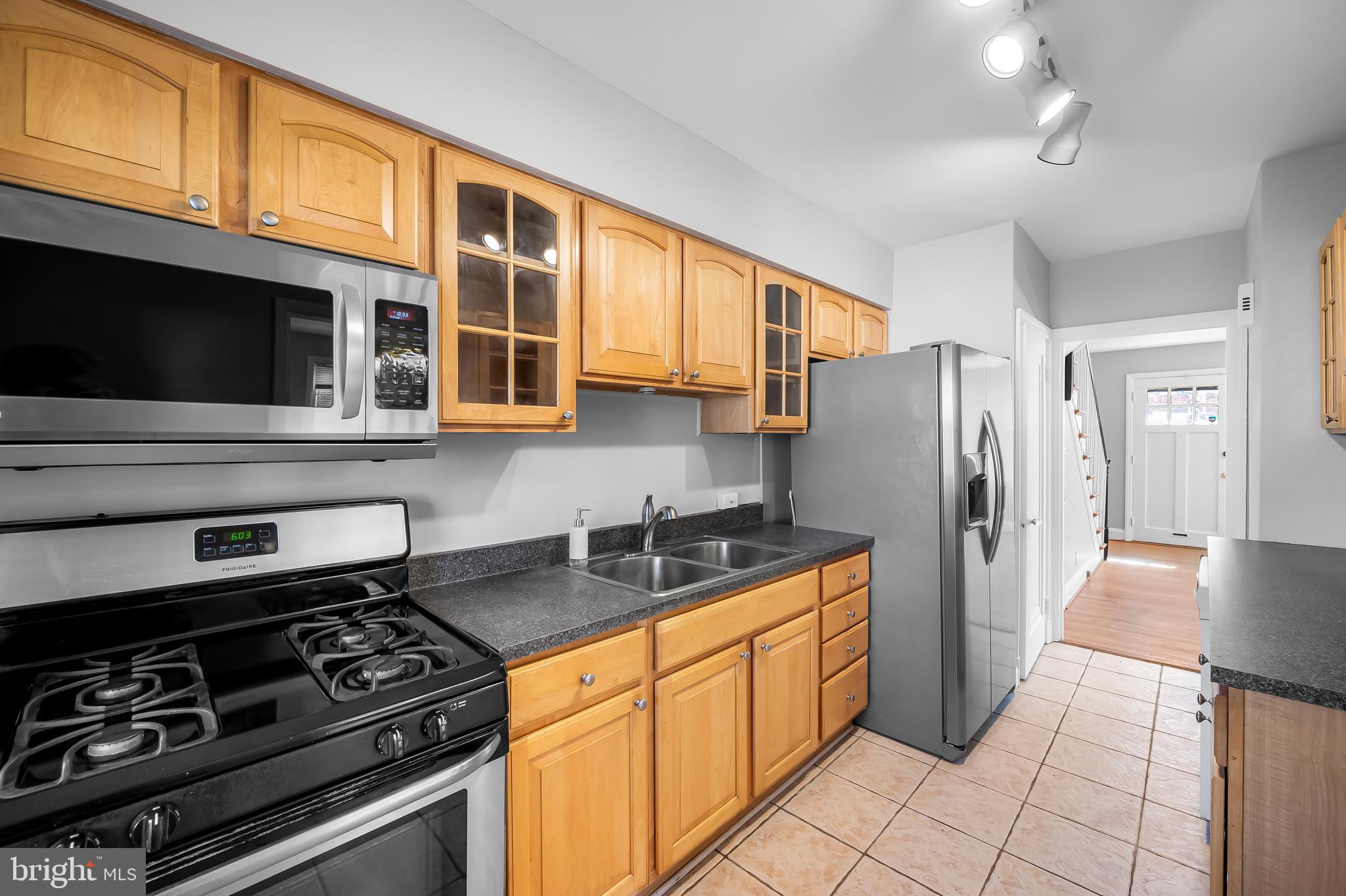 400 Regester Avenue Baltimore, MD 21212 - Photo 11 of 38 a kitchen with stainless steel appliances granite countertop a stove a refrigerator and a microwave