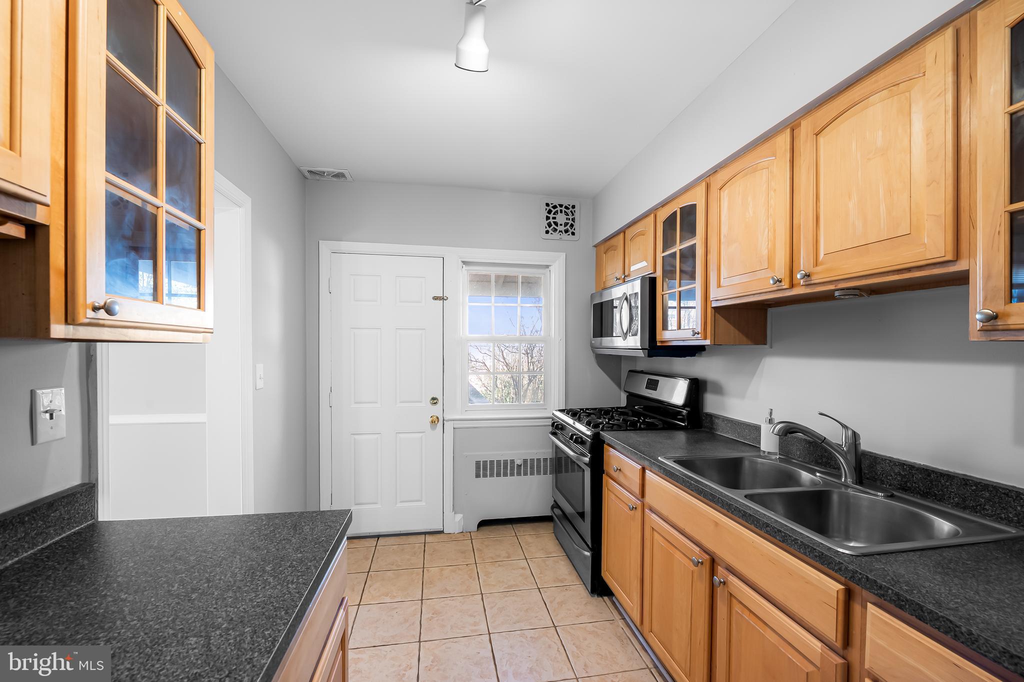 400 Regester Avenue Baltimore, MD 21212 - Photo 13 of 38 a kitchen with stainless steel appliances granite countertop a sink and a stove top oven