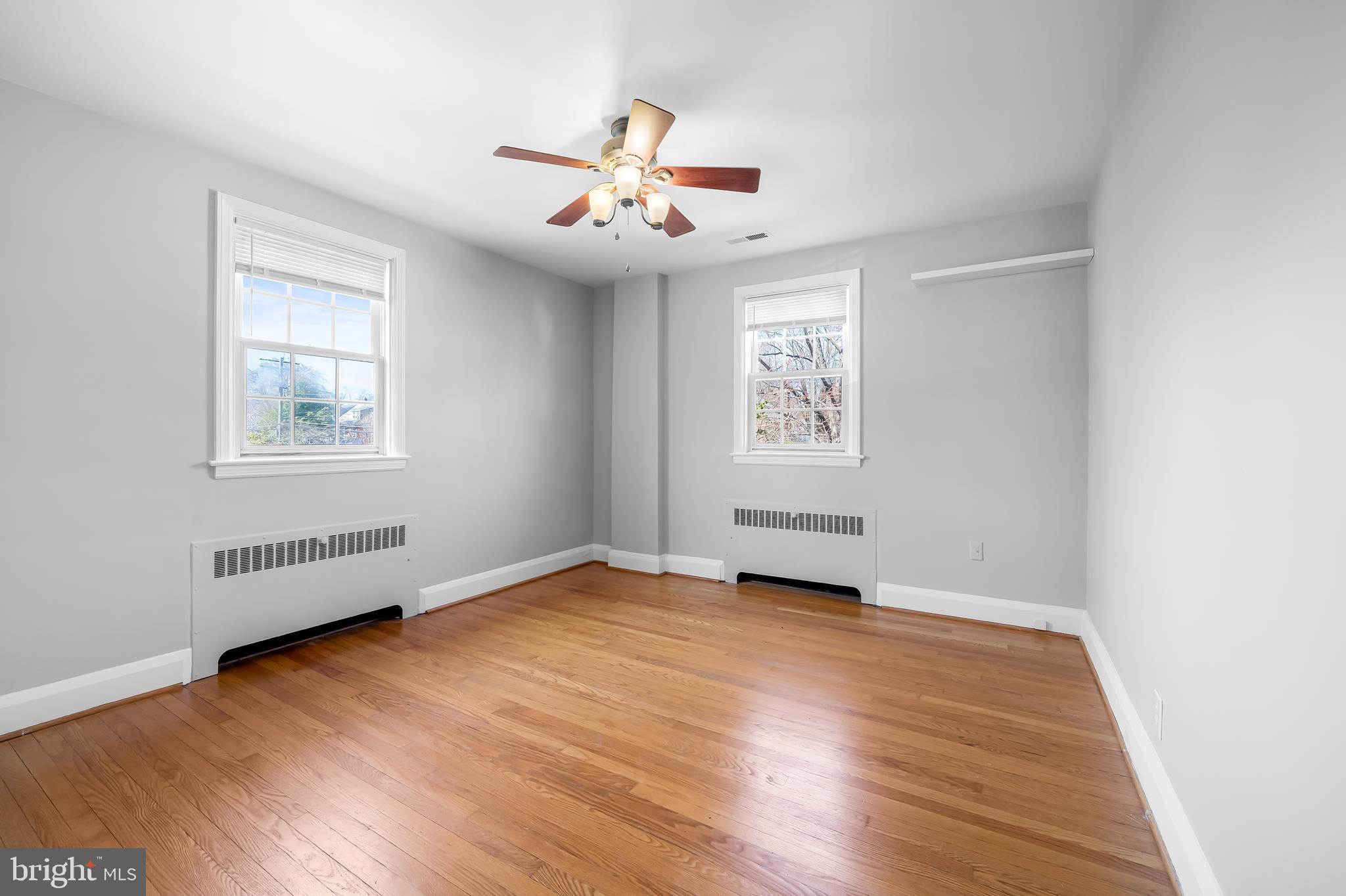400 Regester Avenue Baltimore, MD 21212 - Photo 18 of 38 an empty room with wooden floor chandelier fan and windows