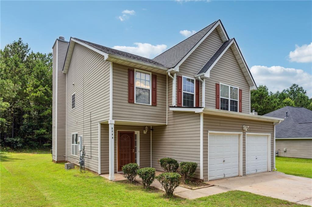 a front view of a house with a yard and garage