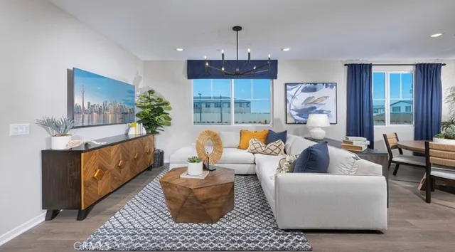 a kitchen with stainless steel appliances kitchen island granite countertop a refrigerator a stove a sink and white cabinets with wooden floor