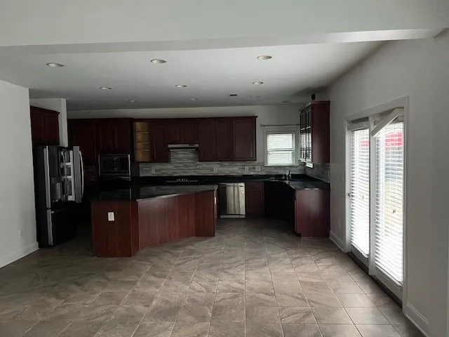 a kitchen with stainless steel appliances granite countertop a refrigerator and a sink