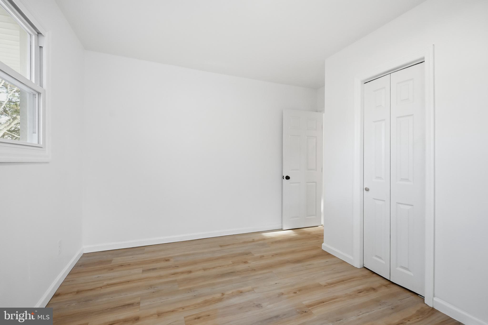 4740 Lake Road Newfield, NJ 08344 - Photo 15 of 29 a view of an empty room with wooden floor and a window