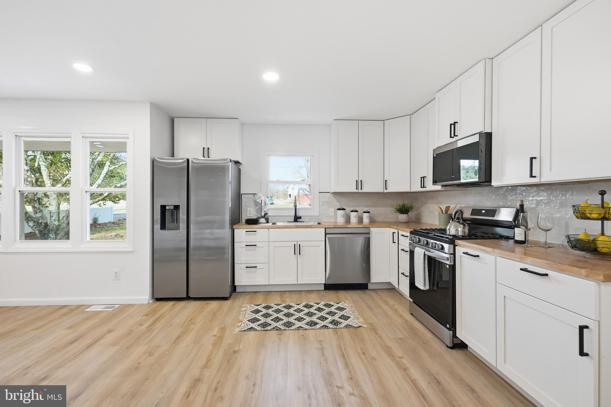 4740 Lake Road Newfield, NJ 08344 - Photo 2 of 29 a kitchen with a refrigerator a stove top oven a sink and cabinets
