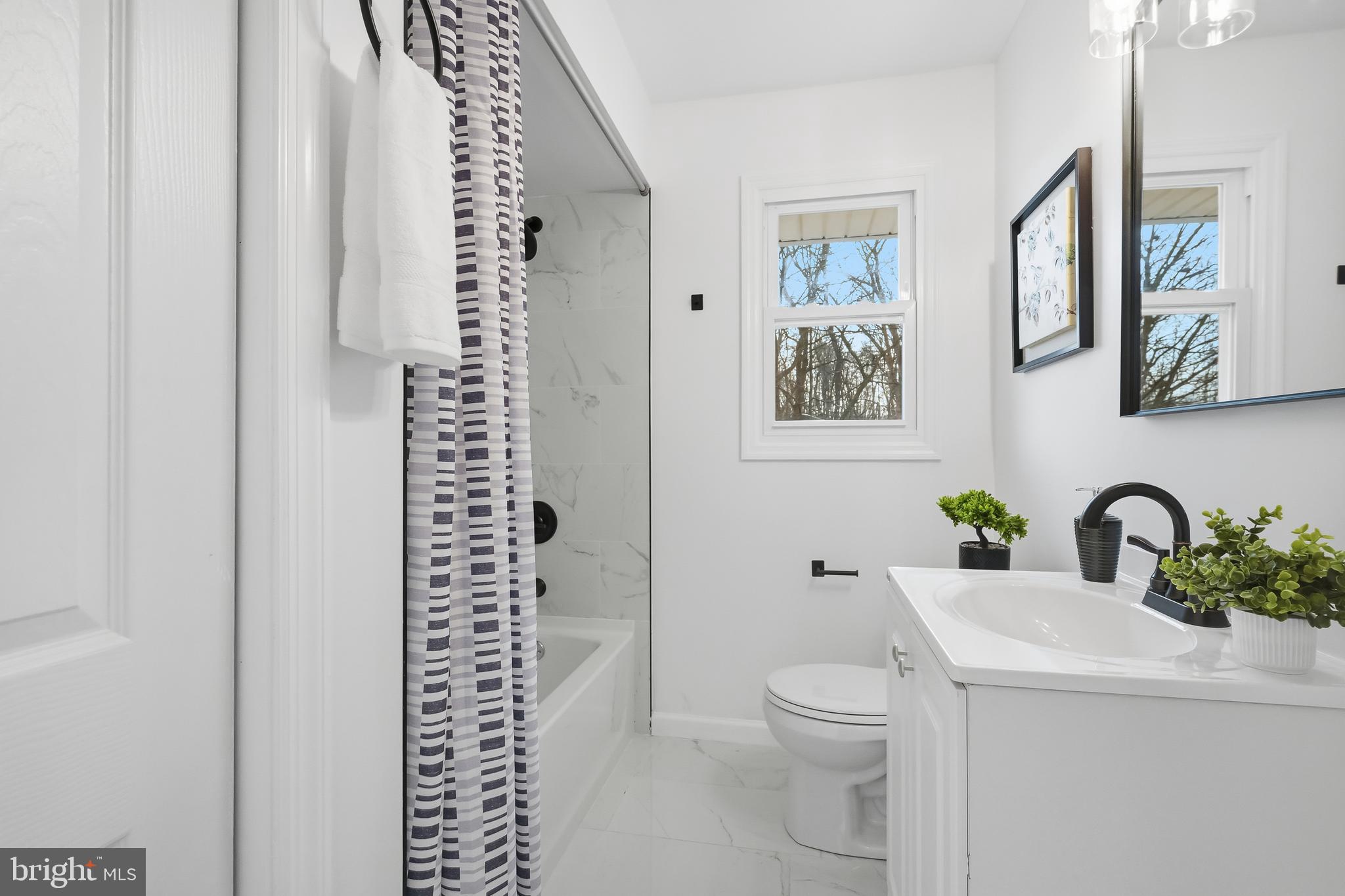 4740 Lake Road Newfield, NJ 08344 - Photo 5 of 29 a bathroom with a toilet a sink and a large mirror