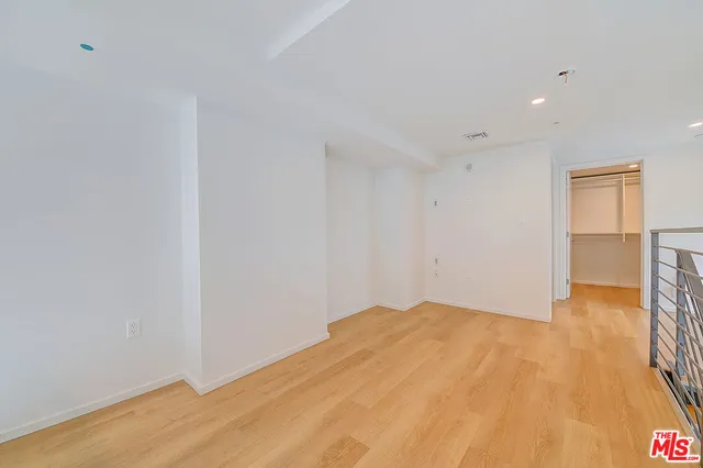 a view of empty room with wooden floor and cabinet