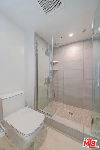 a bathroom with a toilet and a shower