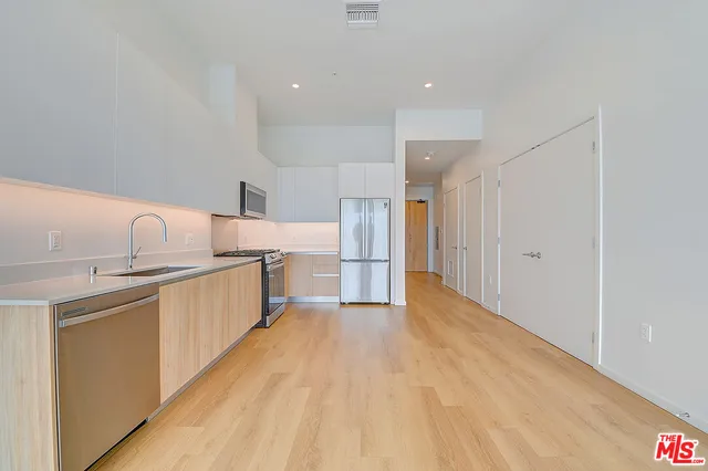 a kitchen with stainless steel appliances a sink and a refrigerator