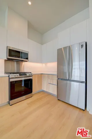 a kitchen with cabinets and a large window