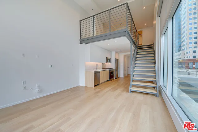 a view of a kitchen with furniture and stairs