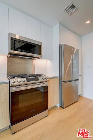 a stove top oven sitting inside of a kitchen