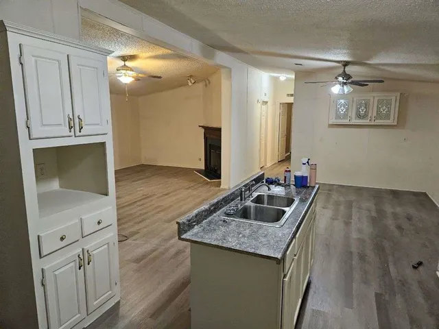 a kitchen with granite countertop a sink and cabinets