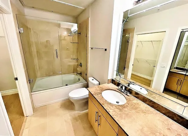 a bathroom with a granite countertop sink toilet and shower