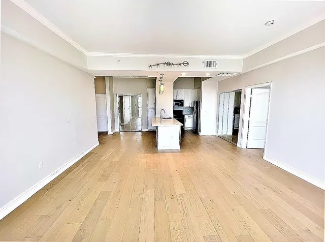 a large kitchen with stainless steel appliances a stove refrigerator and cabinets