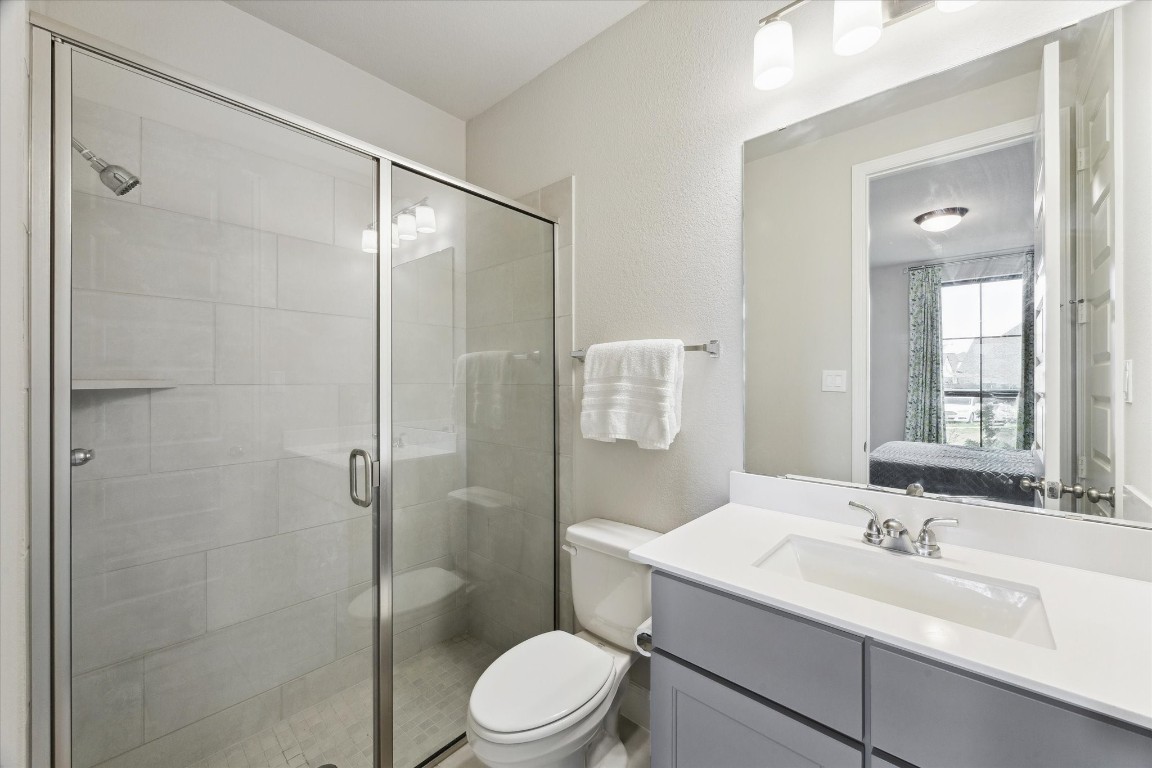 9951 Chapman Trail Manvel, TX 77578 - Photo 27 of 50 a bathroom with a sink toilet vanity and shower