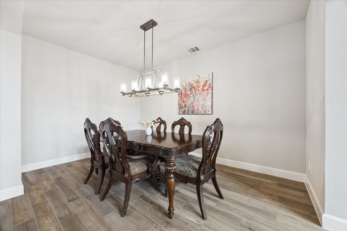 9951 Chapman Trail Manvel, TX 77578 - Photo 8 of 50 a view of a dining room with furniture a chandelier and wooden floor
