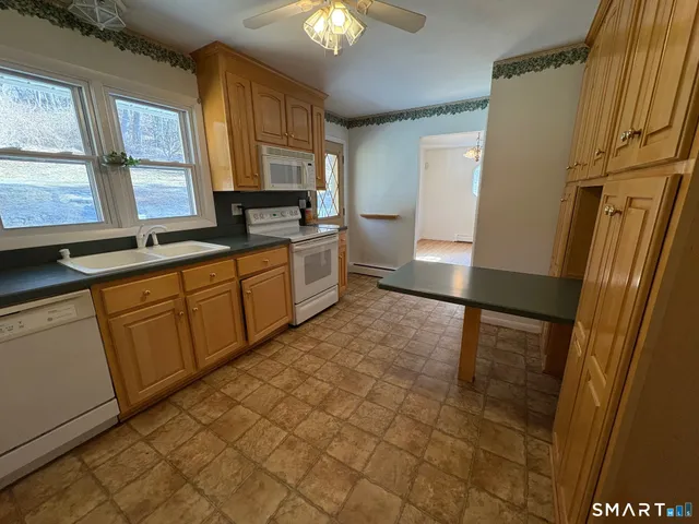 a kitchen with stainless steel appliances granite countertop a refrigerator a stove top oven a sink and dishwasher