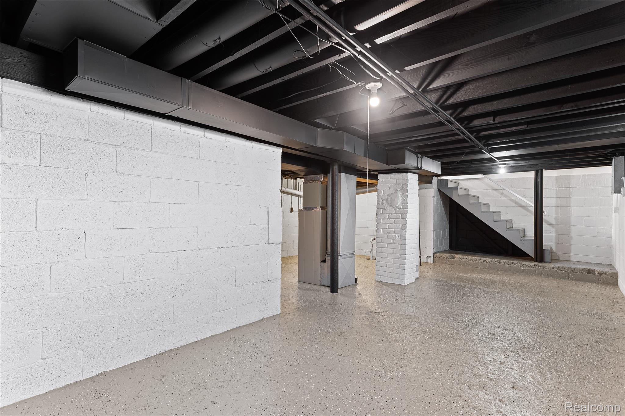 35025 Wick Road Romulus, MI 48174 - Photo 17 of 17 Spacious unfinished basement featuring painted concrete block walls, exposed painted ceiling joists, and a concrete floor