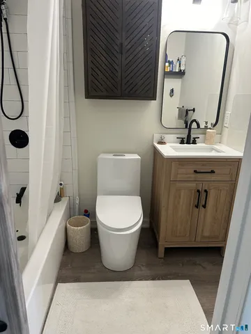 a bathroom with a toilet sink and mirror