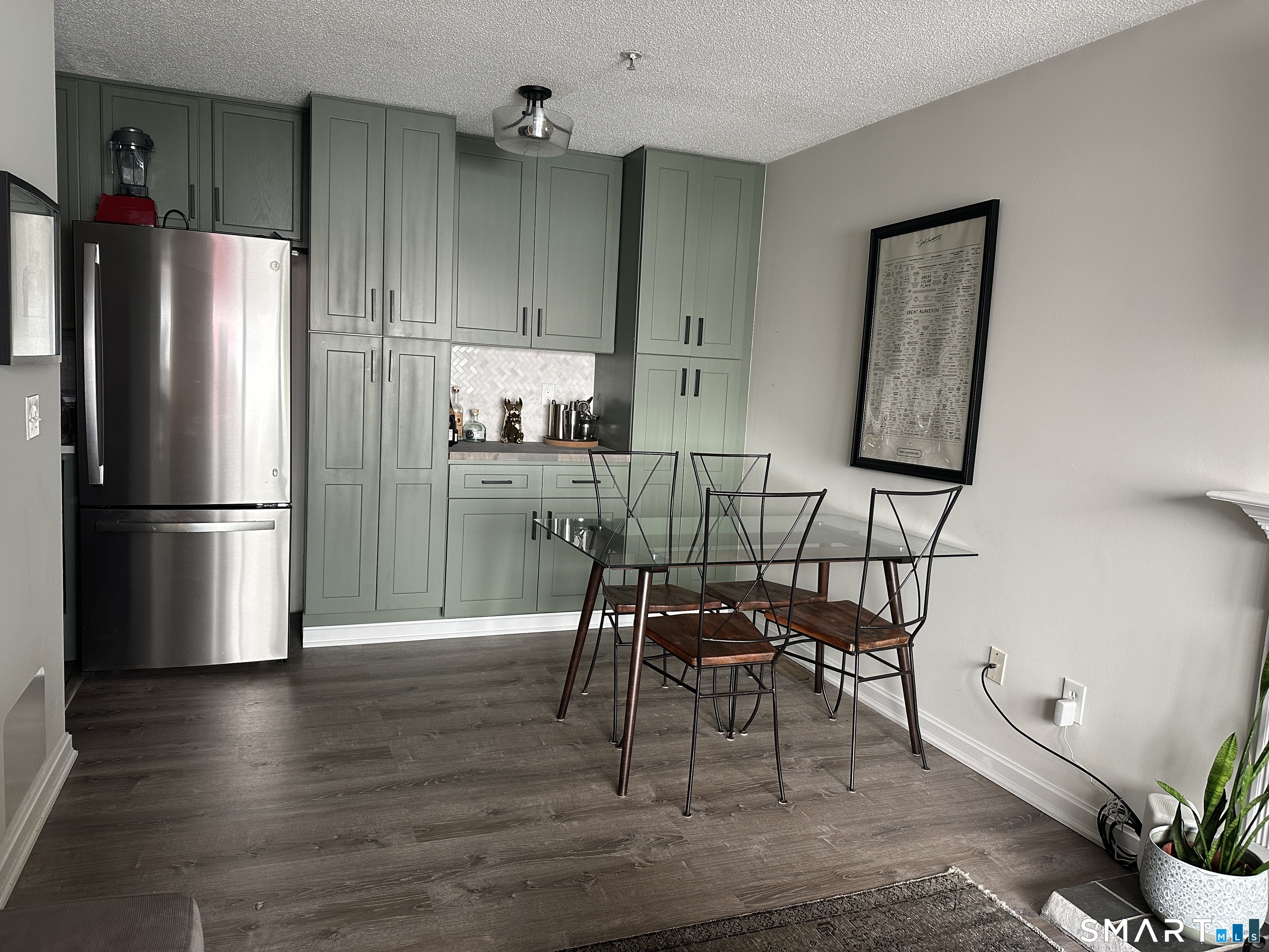 10 Sugar Maple Lane, Unit 10 Ridgefield, CT 06877 - Photo 3 of 13 a kitchen with granite countertop a refrigerator cabinets wooden floor and a dining table