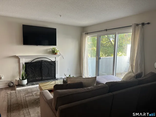 a living room with furniture a fireplace and a flat screen tv