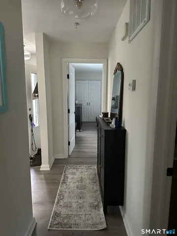 a view of a hallway with wooden floor and a living room