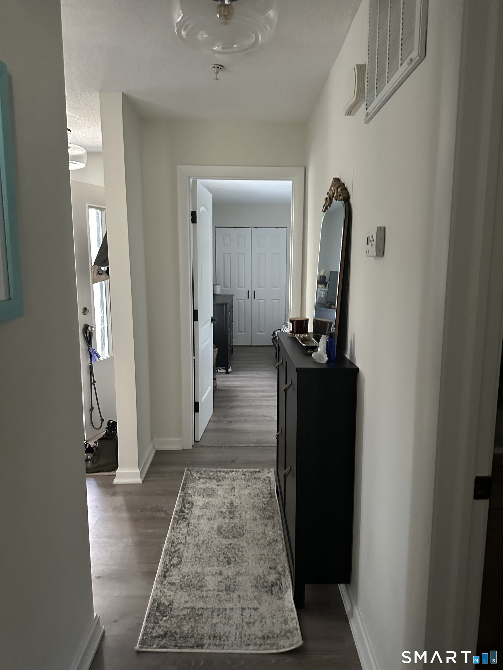 10 Sugar Maple Lane, Unit 10 Ridgefield, CT 06877 - Photo 7 of 13 a view of a hallway with wooden floor and a living room