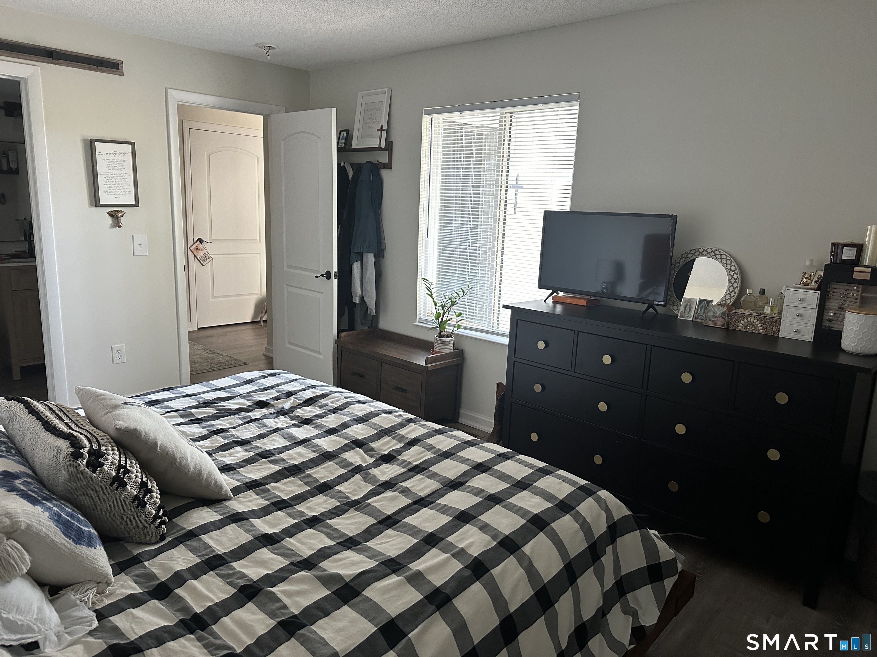 10 Sugar Maple Lane, Unit 10 Ridgefield, CT 06877 - Photo 9 of 13 a bedroom with a bed and a flat tv screen on dresser