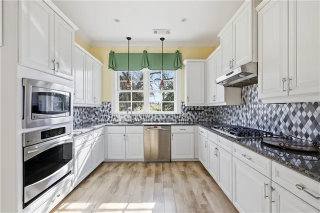 a kitchen with stainless steel appliances a stove sink and cabinets