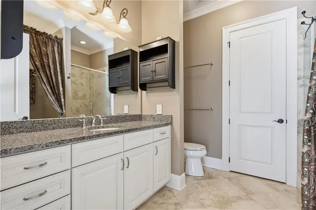 a bathroom with a granite countertop toilet sink and mirror