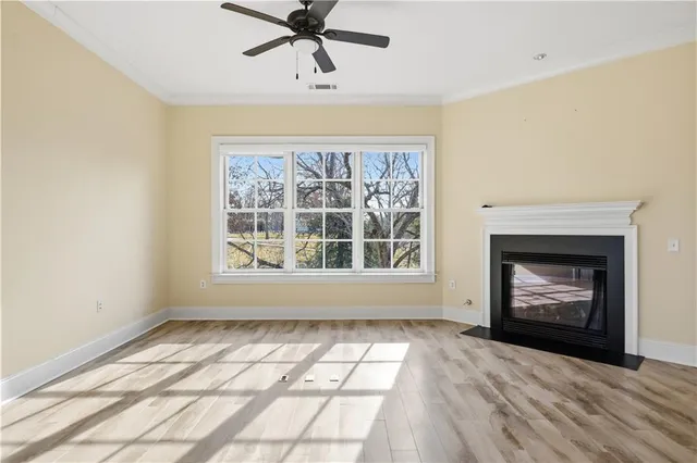 a view of an empty room with a window and fireplace