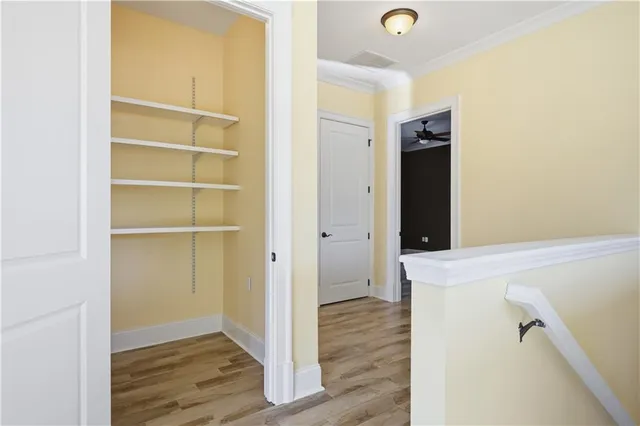 a view of an empty room with wooden floor and closet