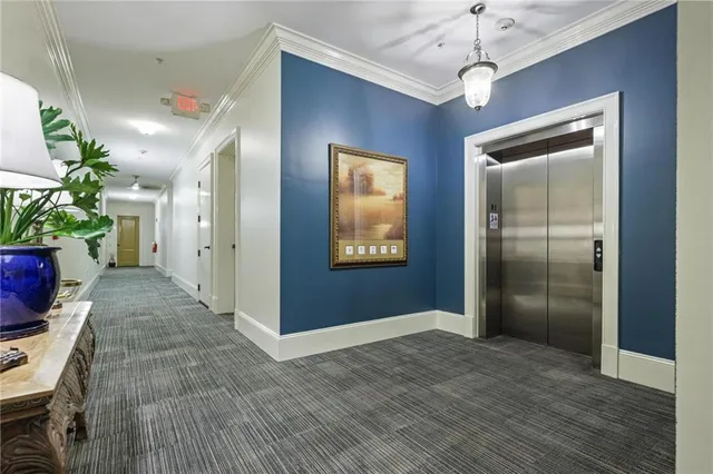a view of a hallway with wooden floor and a chandelier